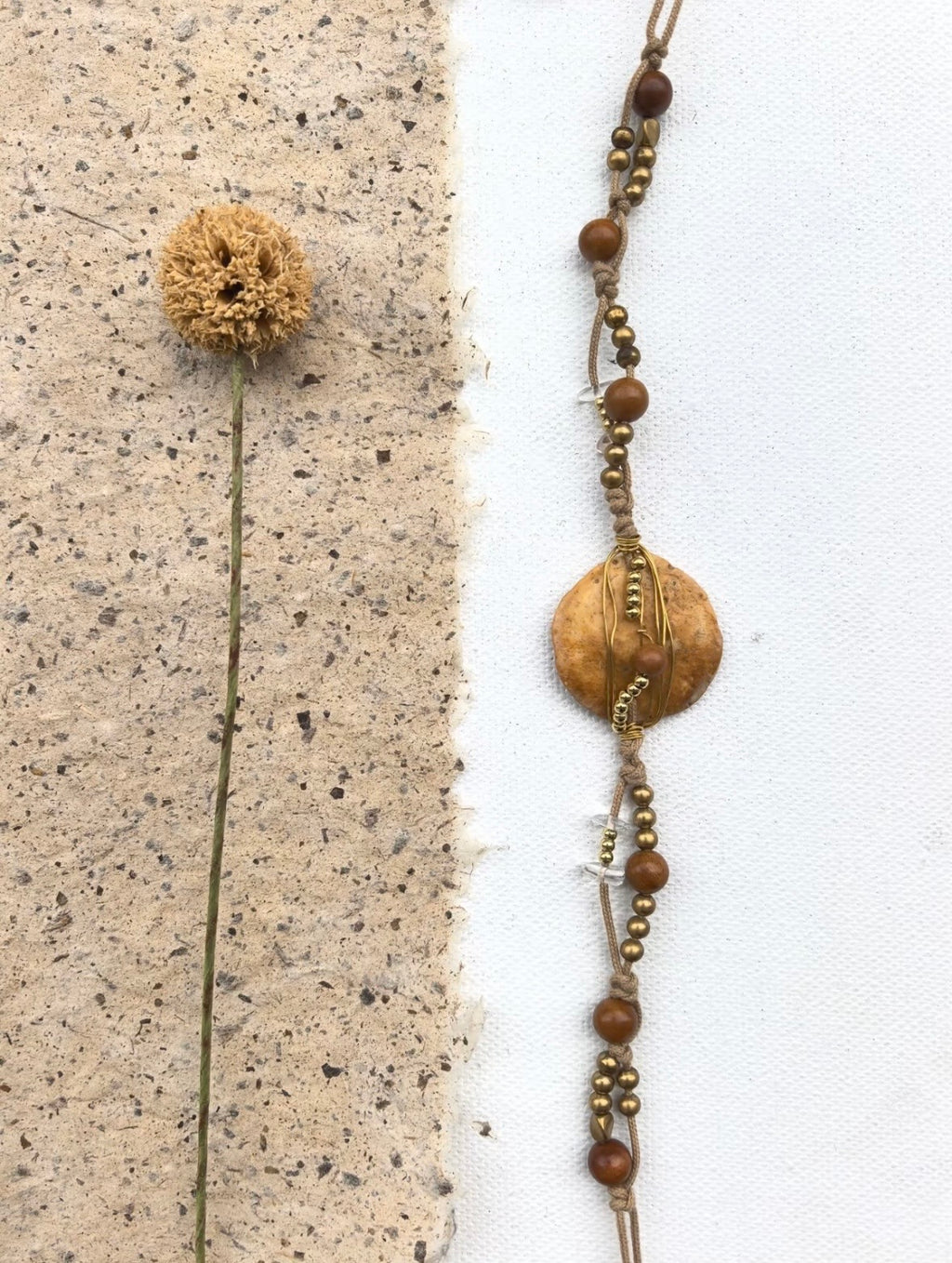 Vertical detail view of a handmade nummulite fossil necklace bracelet with brass and wood beads