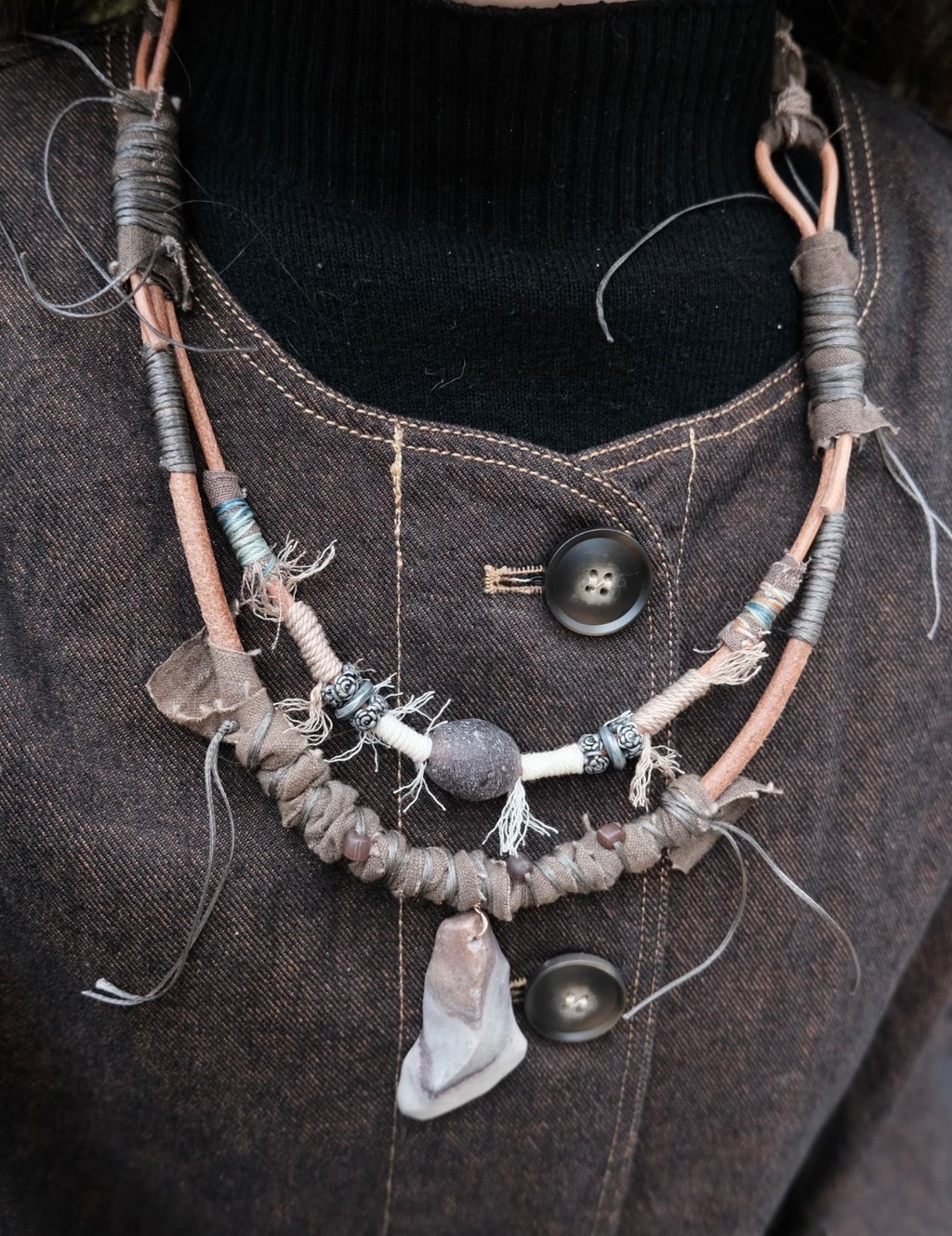 Rustic handmade pendant necklace worn with dark clothing